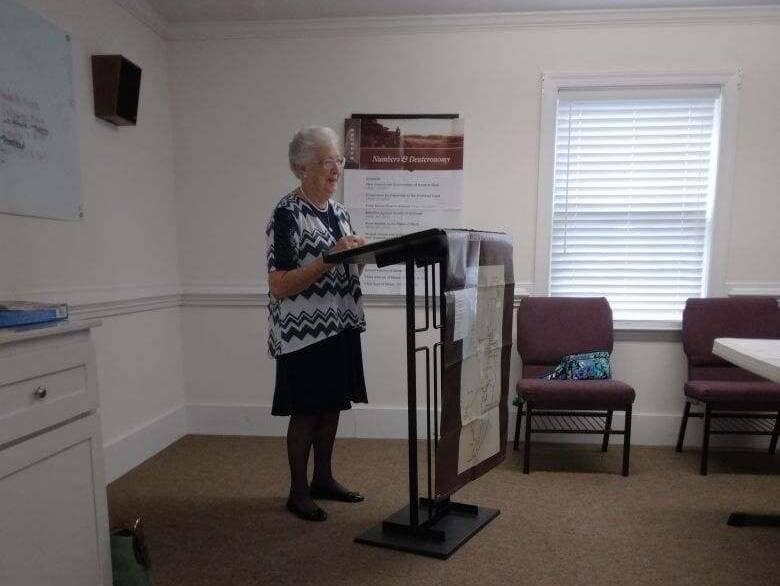 Woman leading Women's Ministry meeting at Rawls Baptist church, standing at a podium