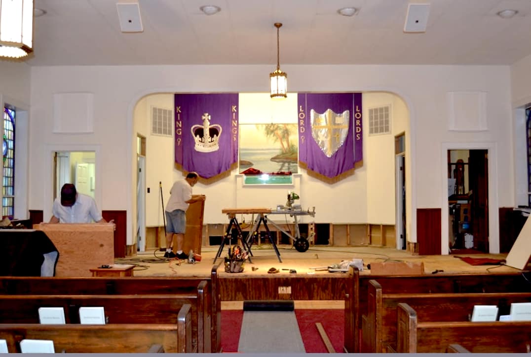 Members working on the pulpit area at Rawls Baptist Church during the 2013 sanctuary renovation, with tools and materials visible in progress.