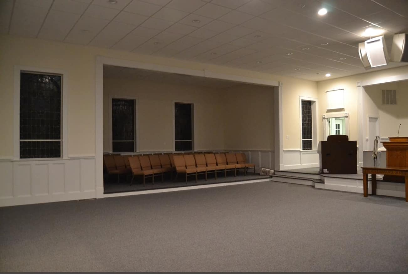 Side View of Sanctuary After Renovation (2014) Side section of Rawls Baptist Church sanctuary after renovation, showing new wall paneling, seating, and soft lighting.