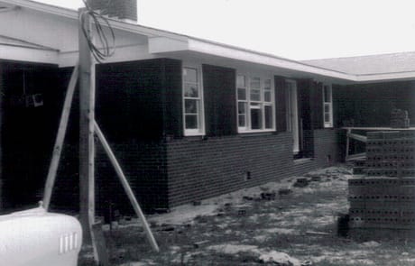 Final Brickwork and Exterior Finishing Construction of the Rawls Baptist Church parsonage in Fuquay-Varina, NC, during July 1960, showing progress and congregation involvement.