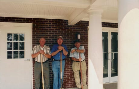 Finishing Touches on the Entrance, 2005 Three members of Rawls Baptist Church standing by the completed addition in 2005, marking the end of construction efforts.