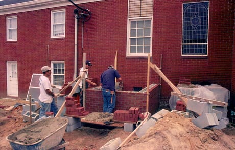 Laying the Foundation, 2005 Brick masons begin laying the foundation and walls for the new wing of Rawls Baptist Church during the 2005 expansion project.