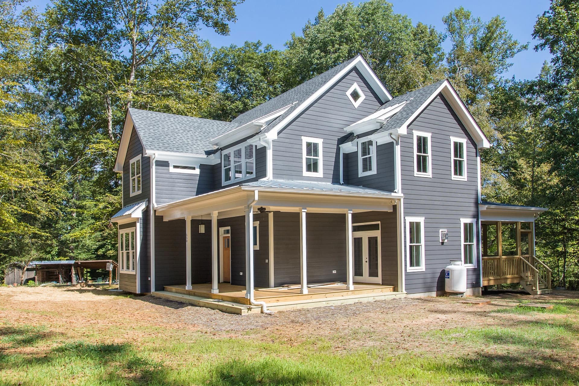 Custom home exterior in Pittsboro, North Carolina with covered porch and wooded lot