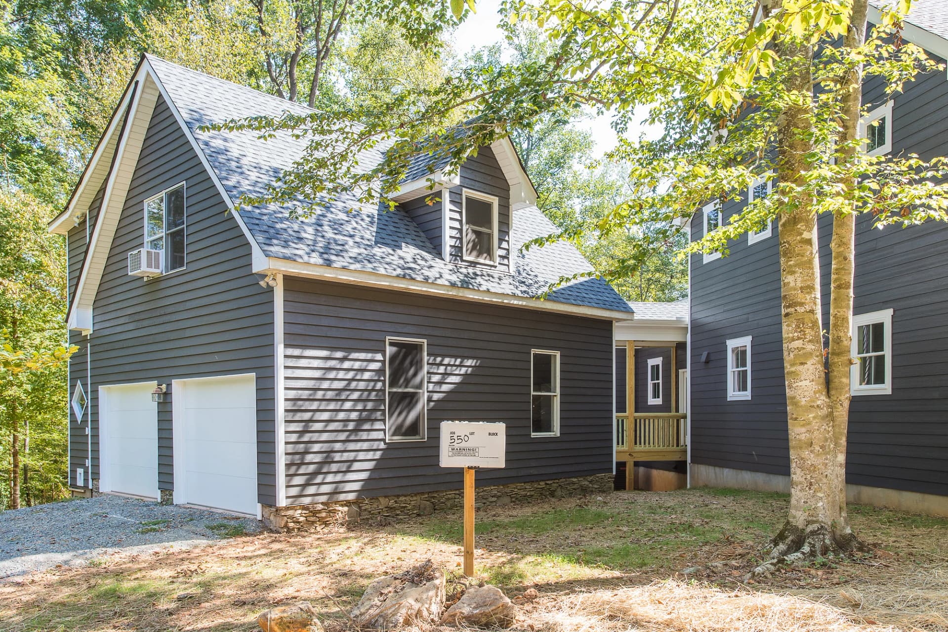 Detached garage and side elevation of custom home in Pittsboro NC surrounded by trees