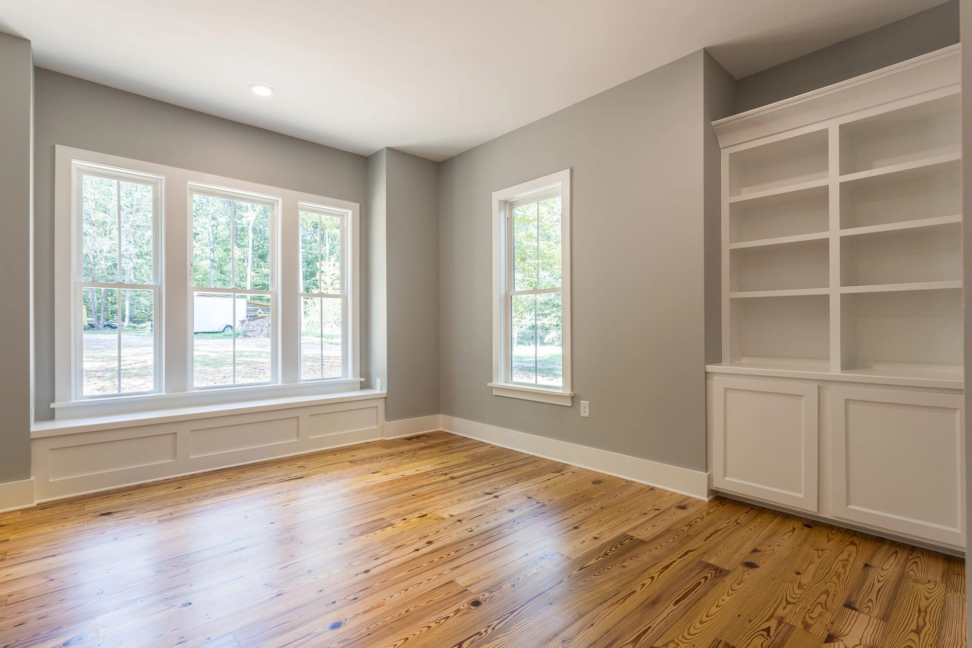 Bedroom with built-in storage and large windows in Pittsboro custom home
