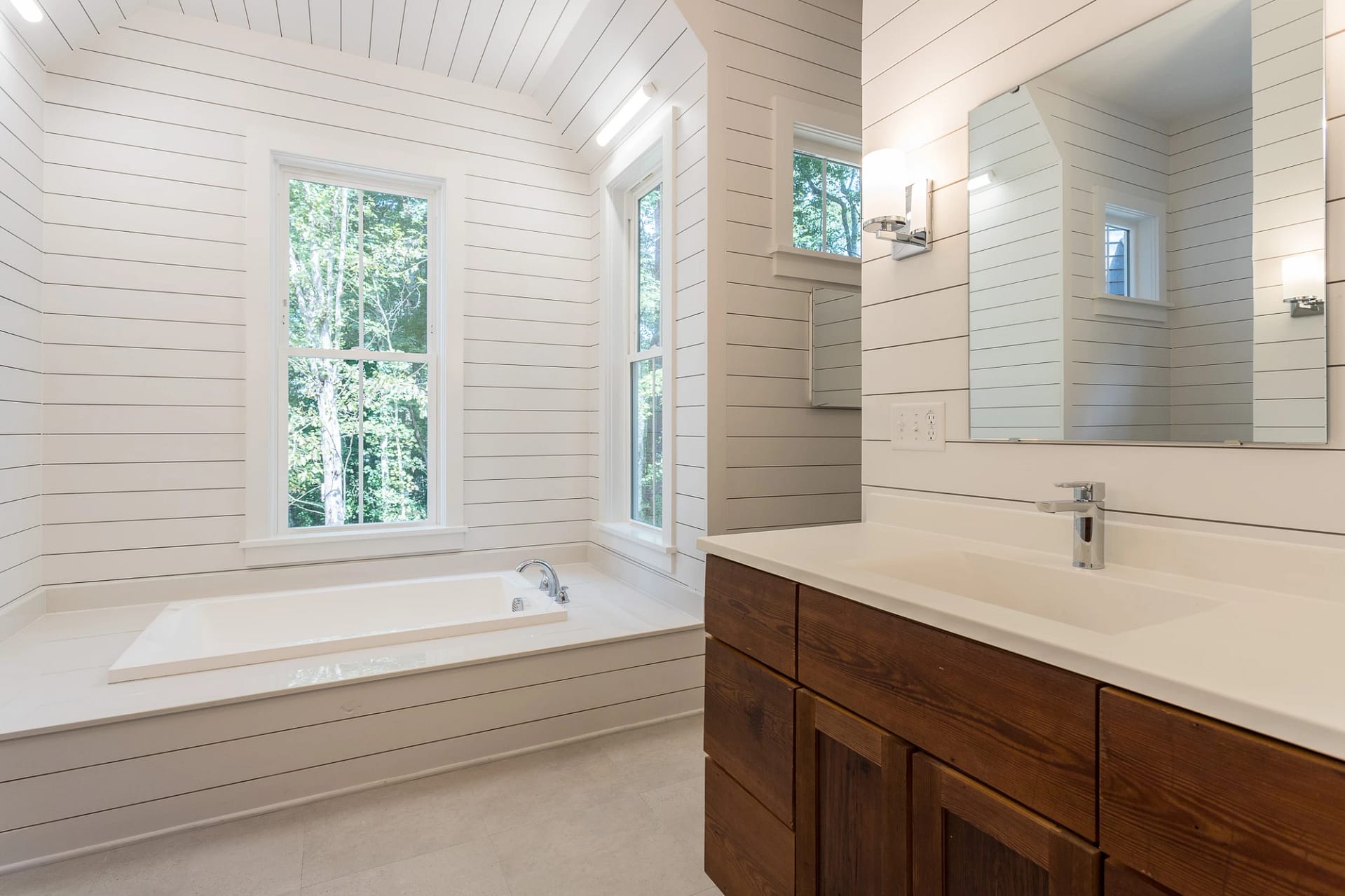 Primary bathroom with soaking tub and wood vanity in Pittsboro custom home