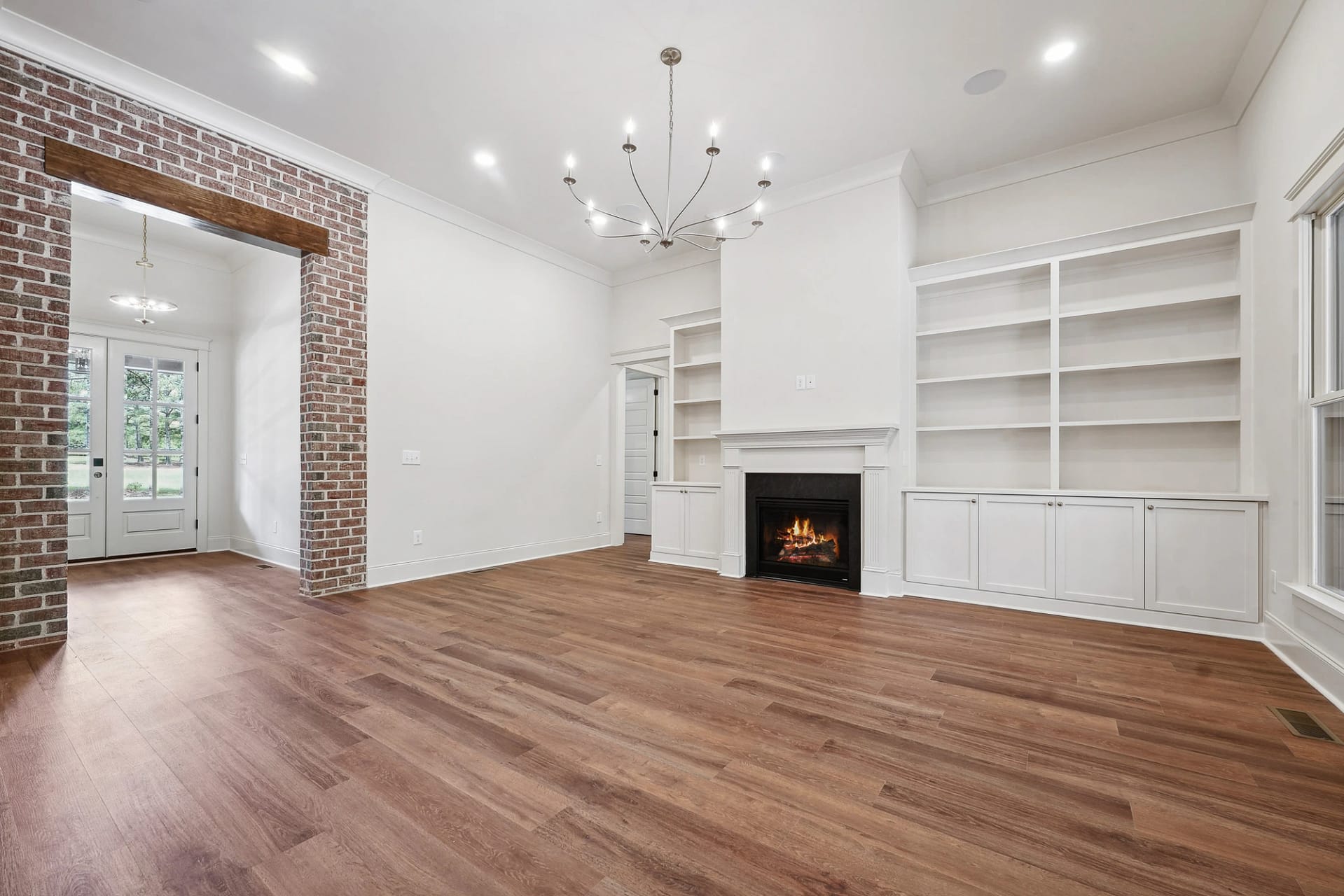 Living room with built-in shelving and fireplace in Holly Springs custom home