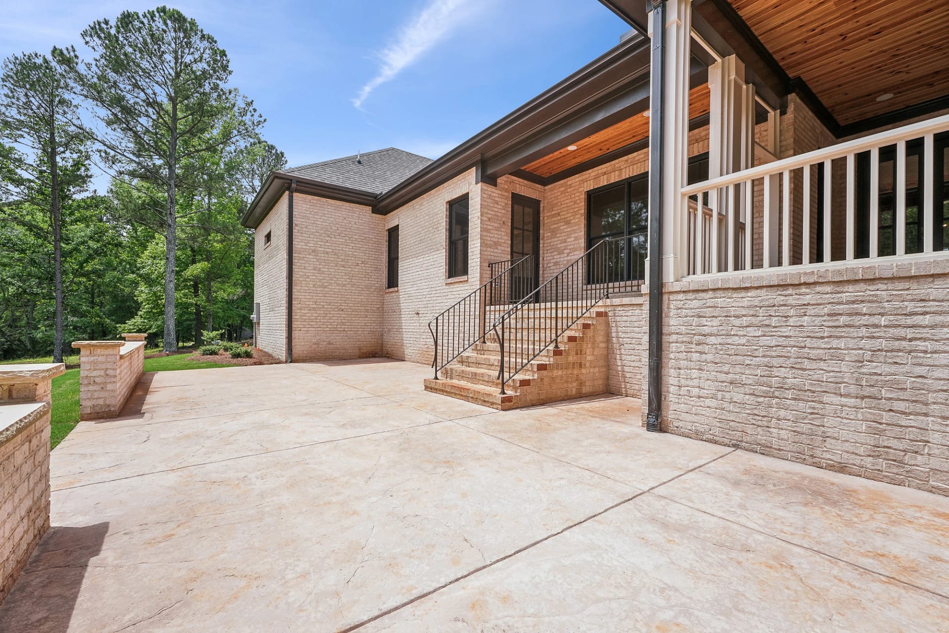 Side patio and brick walkway leading to covered porch in Holly Springs custom build
