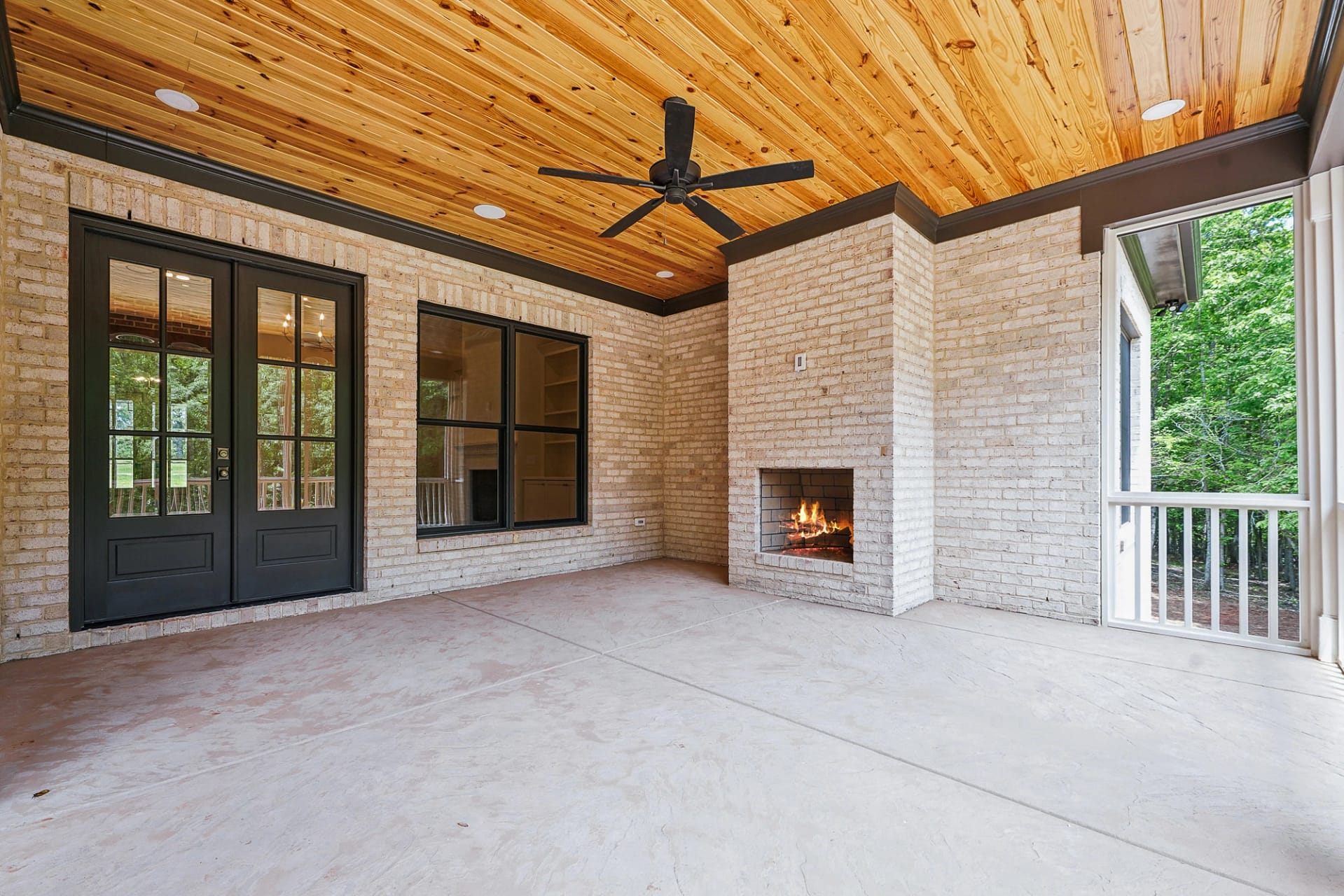 Screened porch with brick fireplace and wood ceiling in Holly Springs home