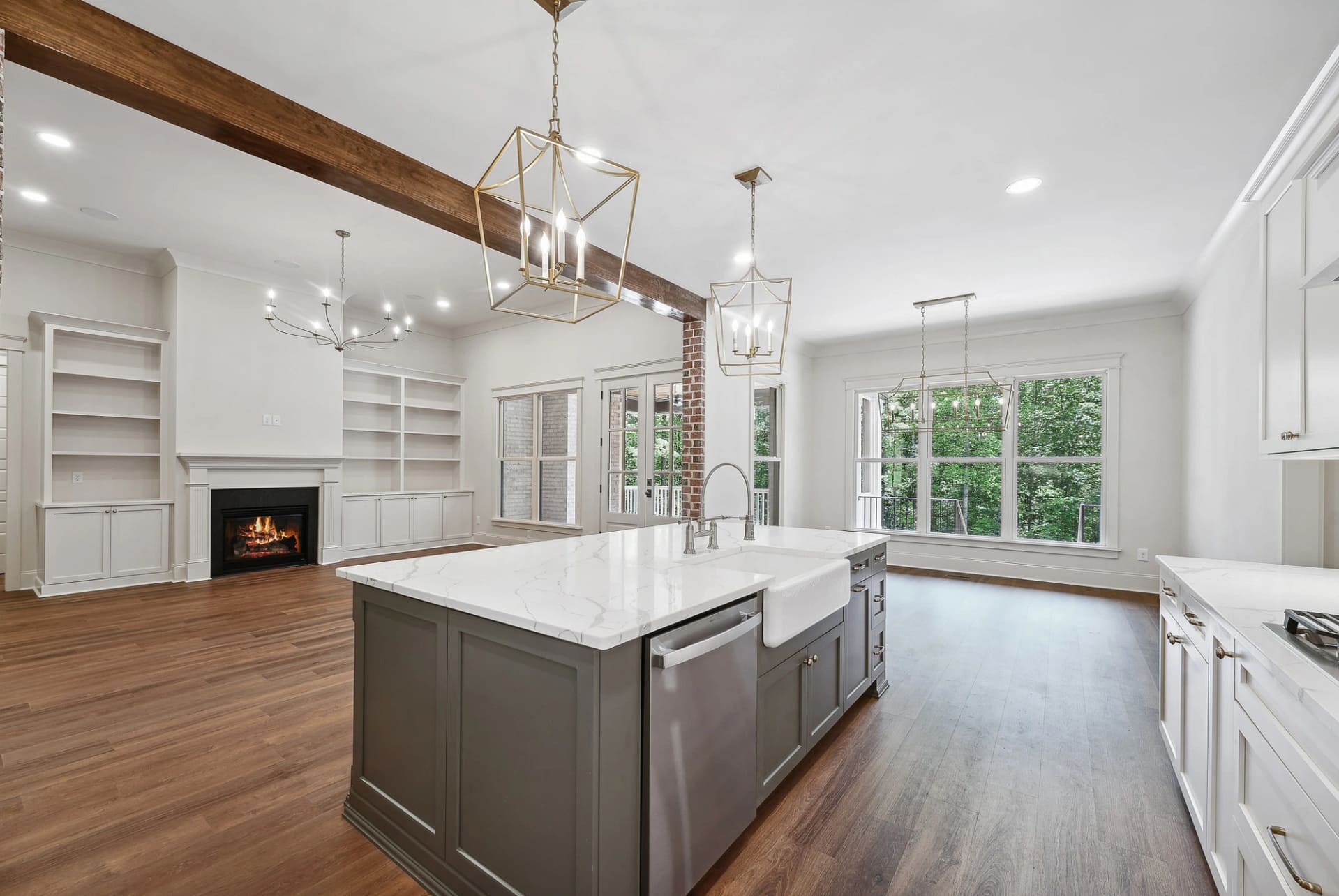 Open kitchen and living area with exposed beam and fireplace in Holly Springs home