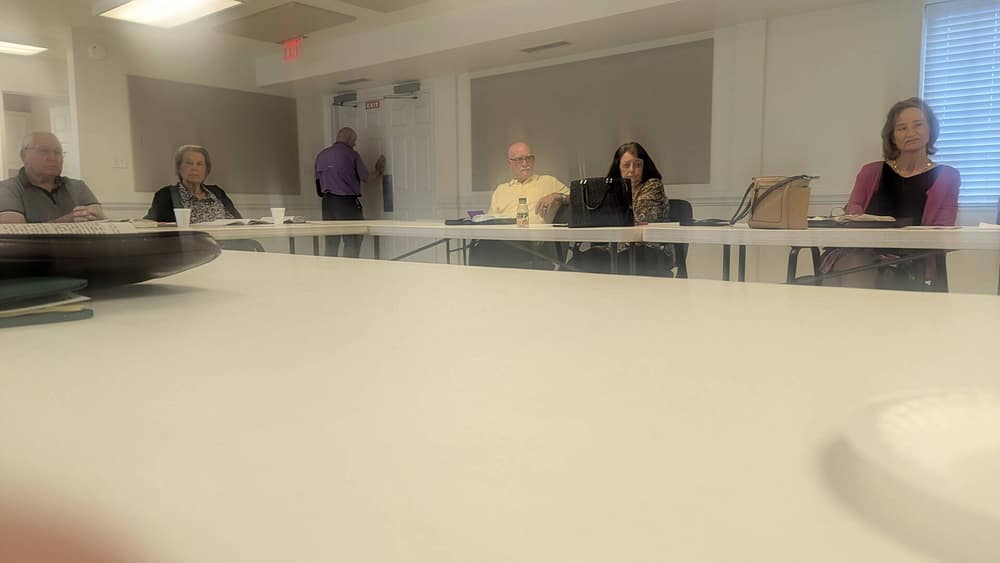 Men and women gathered together at Sunday School class listening to teacher who isnt in view