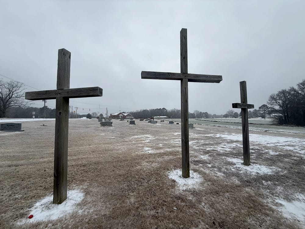 3 large crosses on top of brown grass with snow on the basin in the Rawls Baptist church Cemetary