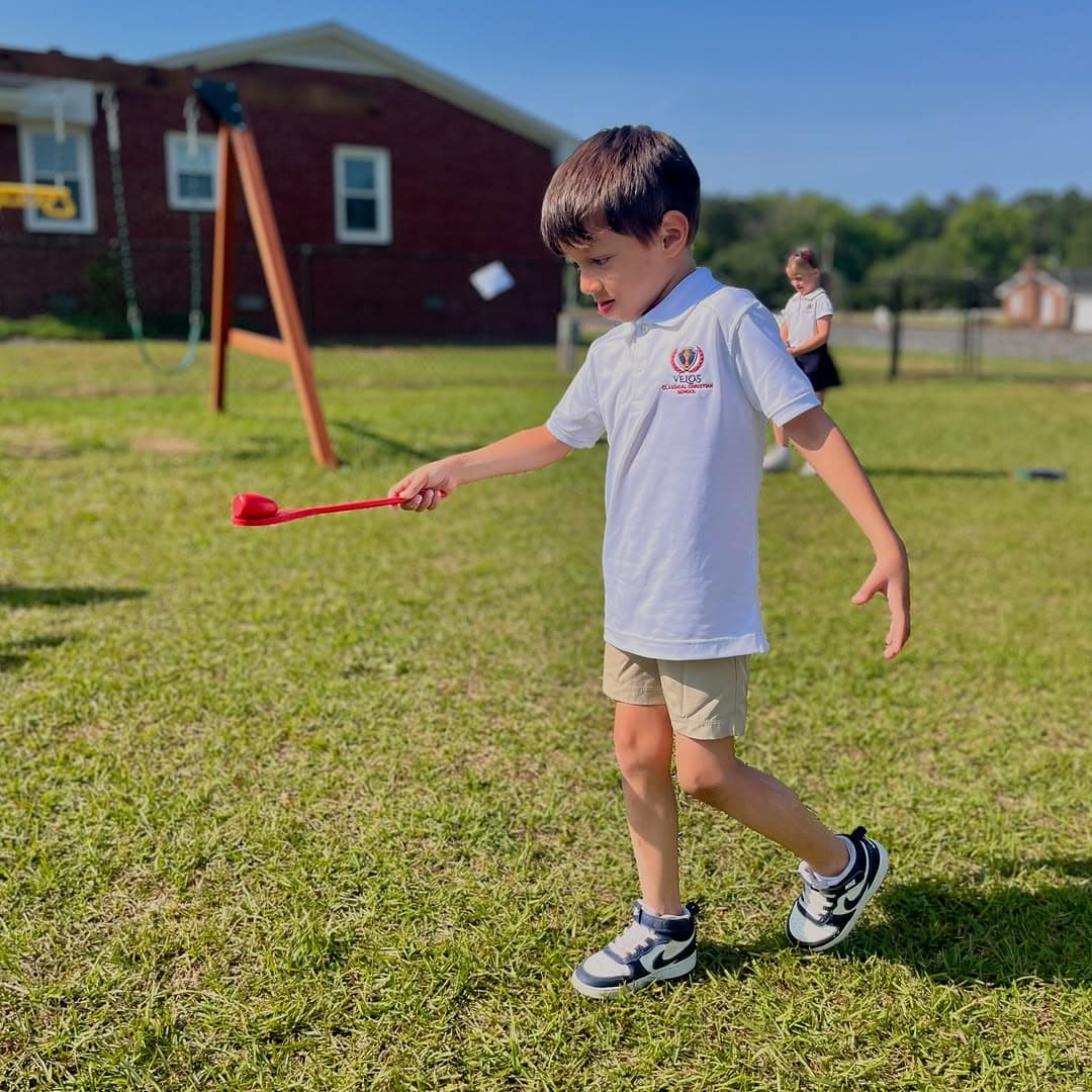 boy_playing_velos Boy student playing outside of Rawls Baptist Church at Velos Classical Christian School