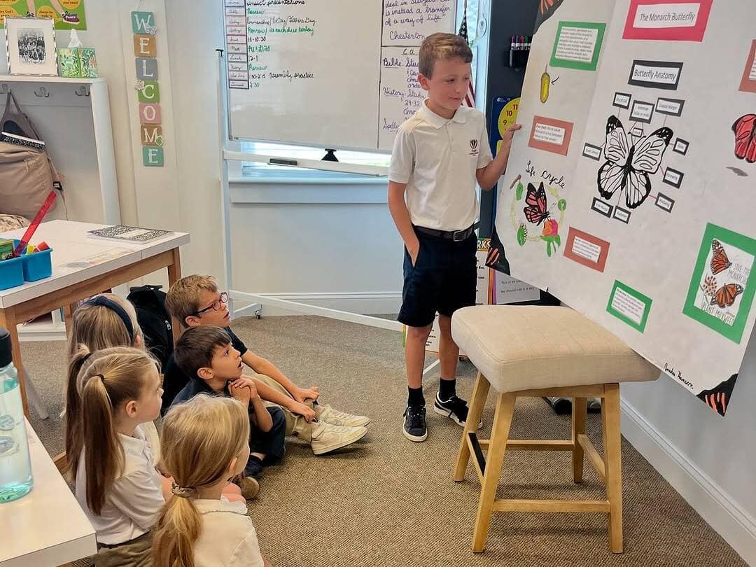 boy_presenting_to_students Boy showing assignment to other students at Velos Classical Christian School at Rawls Baptist Church