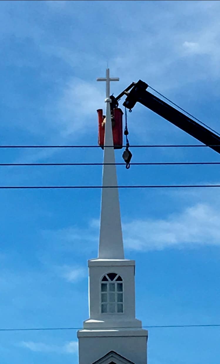 Cross Mounted on the New Steeple (2018) Workers secure the new steeple cross atop Rawls Baptist Church in 2018, completing installation under clear blue skies.