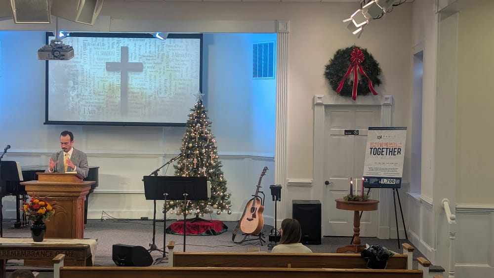 Pastor Brandon Gaster preaching in Rawls Baptist Church Sanctuary while its decorated for Christmas