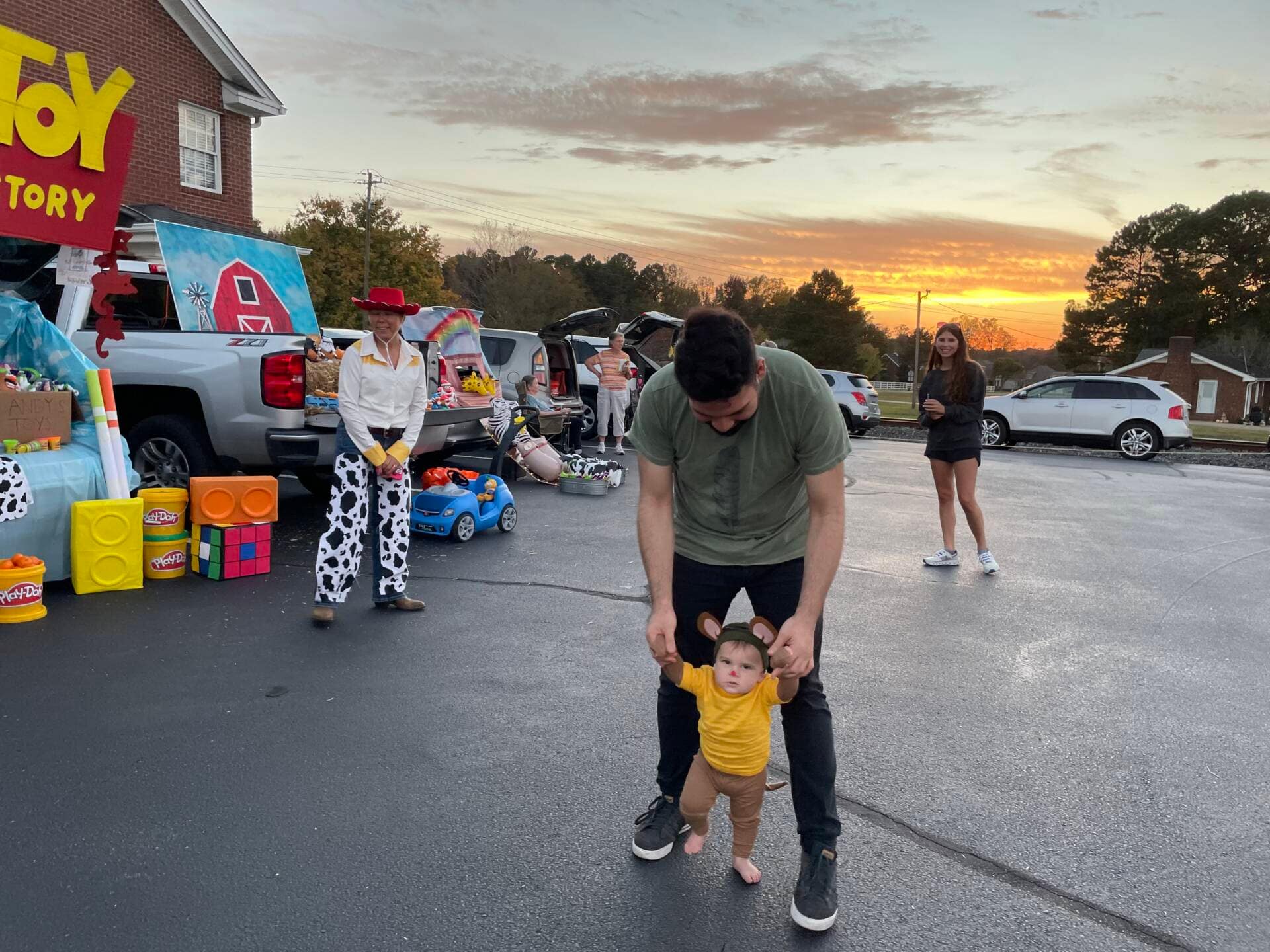 Rawls Baptist Church 2024 Trunk or Treat Kid being held by his father with other attendees walking around.