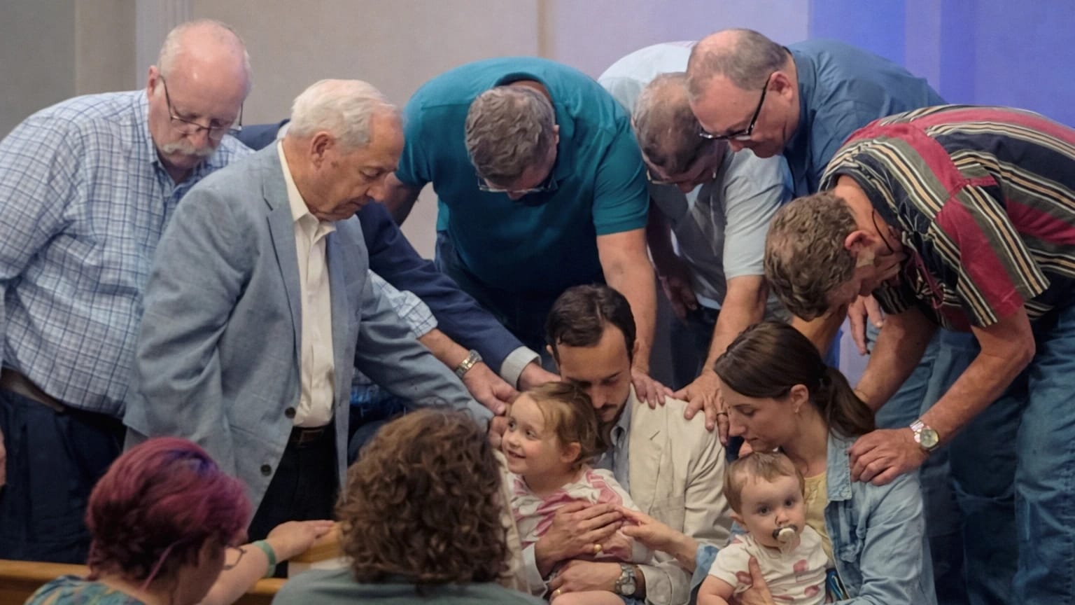 Deacons praying with pastor and family at Rawls Baptist Church revival