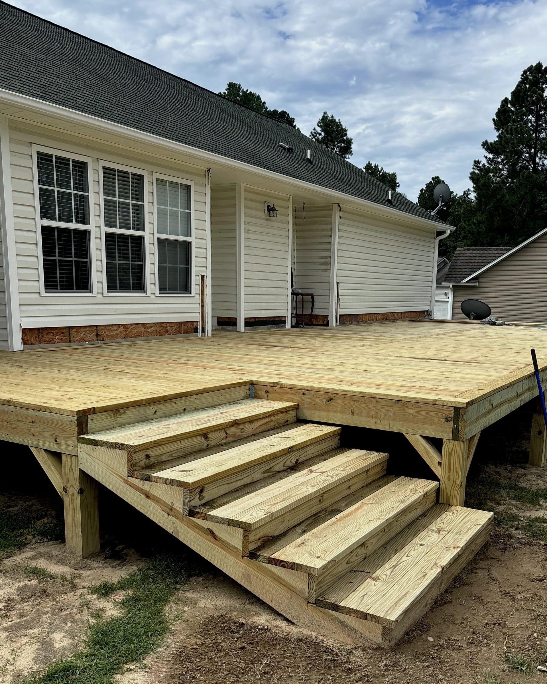 Ground-level deck with wide wood stair entry and open layout.