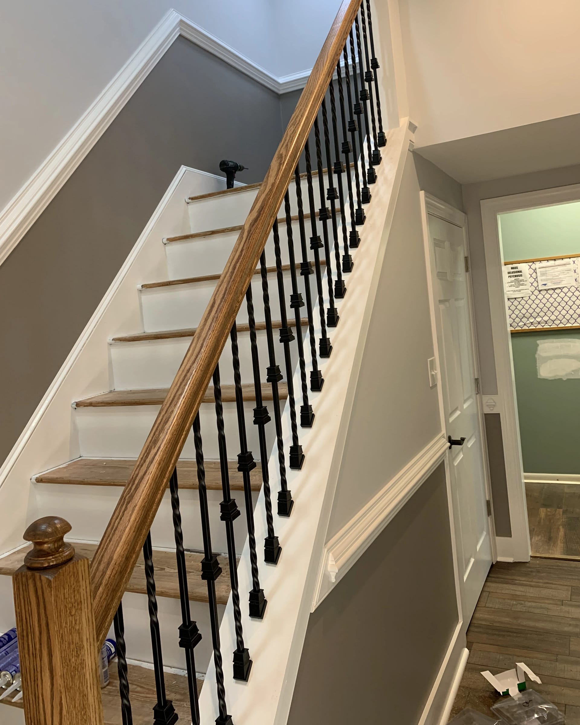 Staircase with freshly painted trim and newly stained railing and steps.