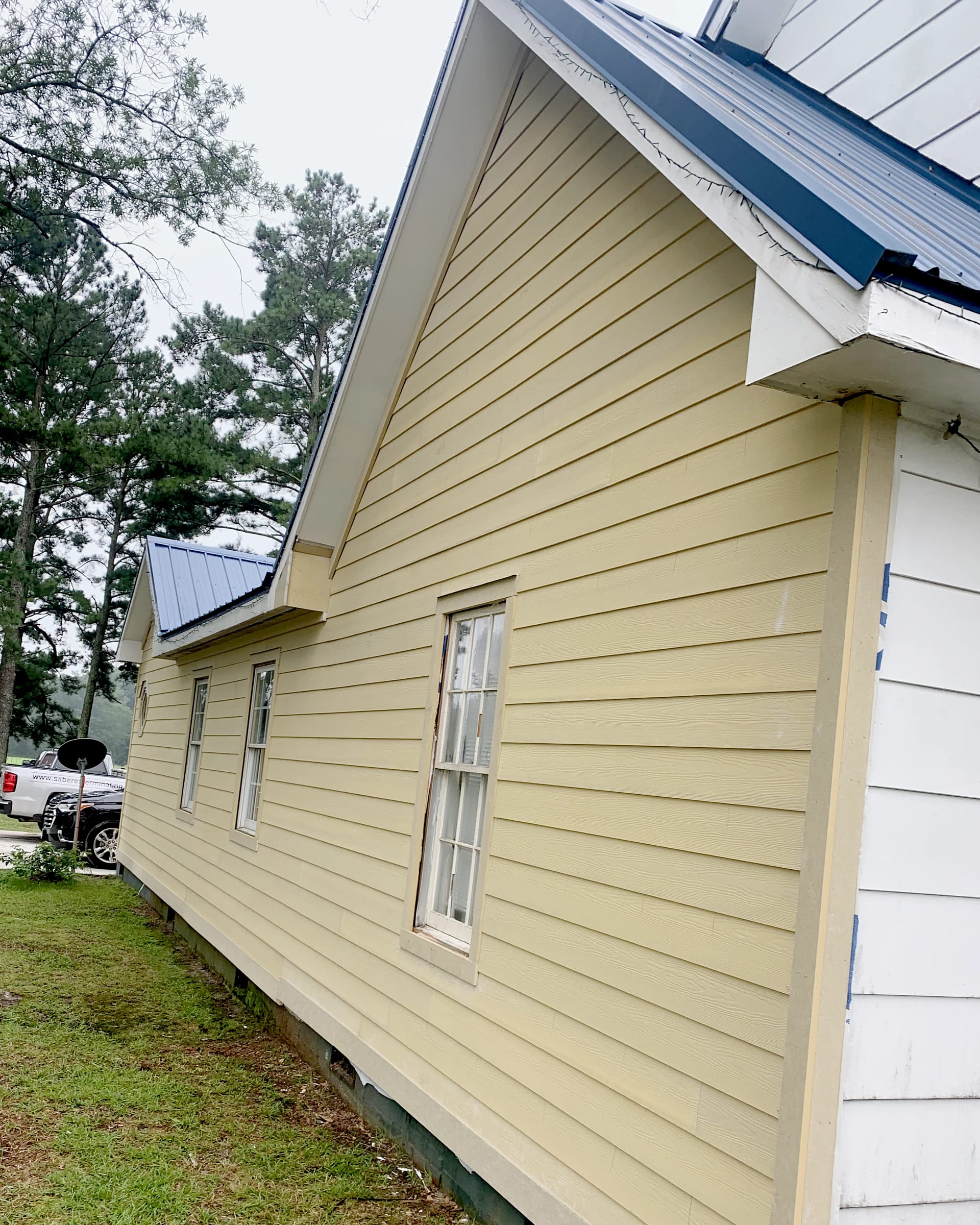 Hardie board siding installation in progress with new panels fitted along the exterior wall.