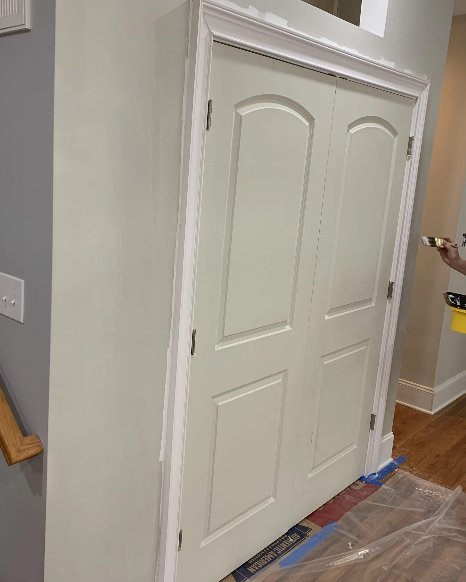 Closet doors and trim freshly painted with clean white finish during interior painting work.