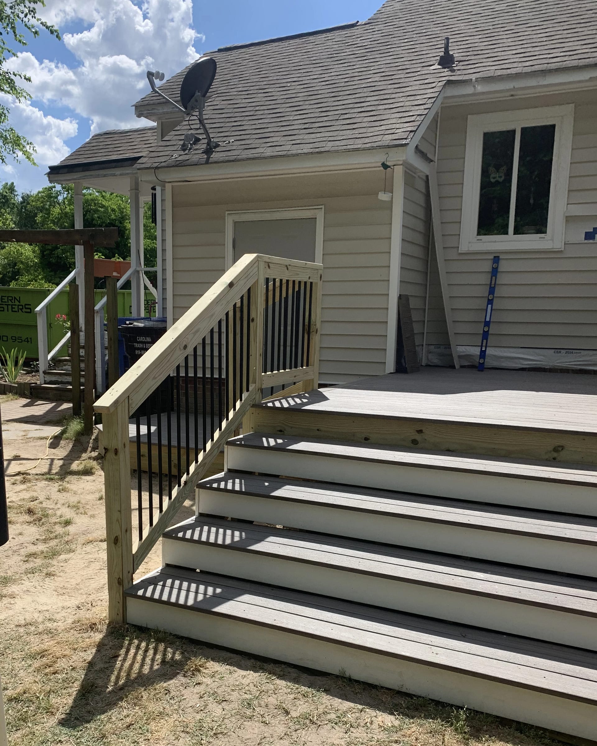 Wood deck stairs with railing leading up to a multi-level platform.