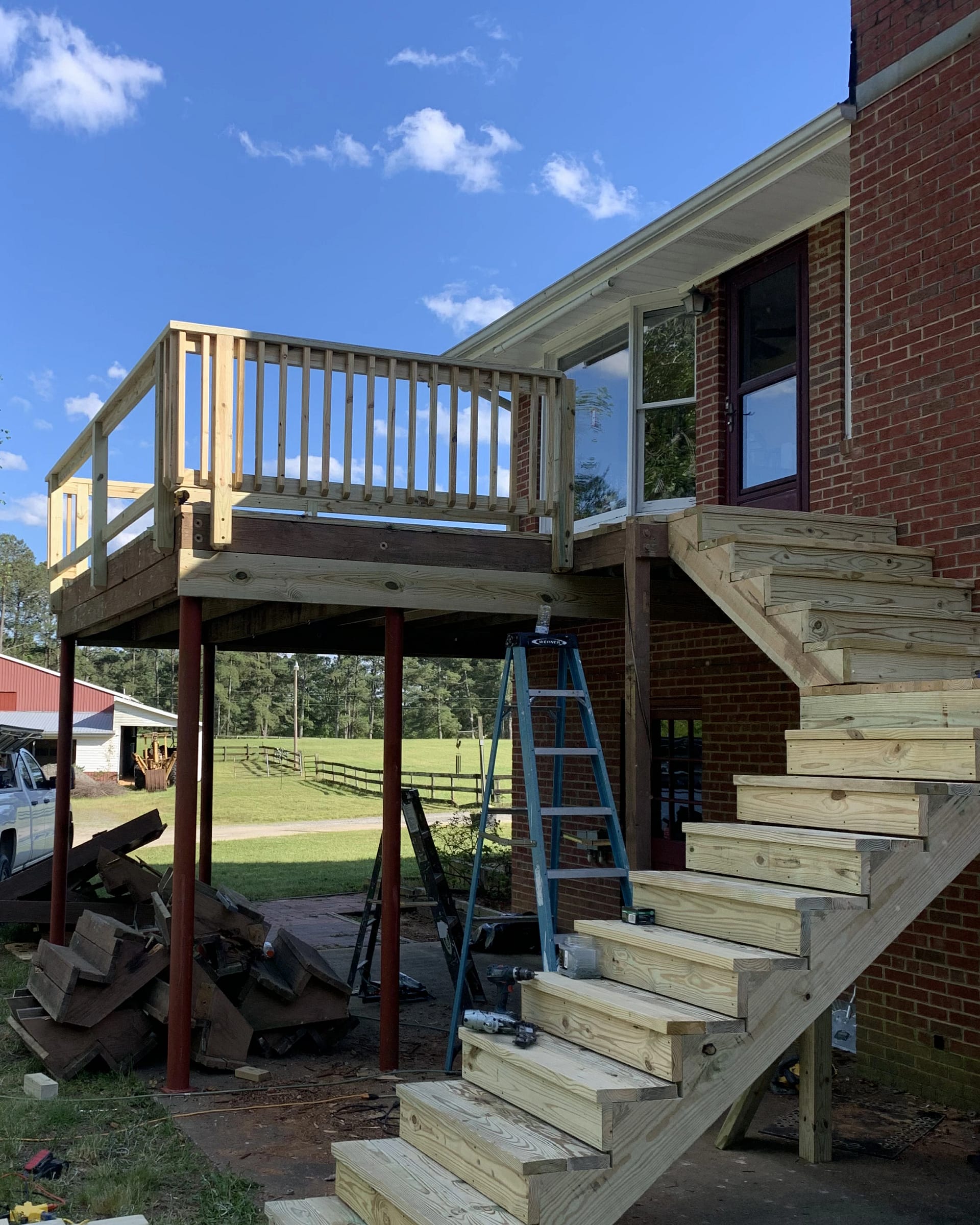 Elevated deck under construction with new stair framing.