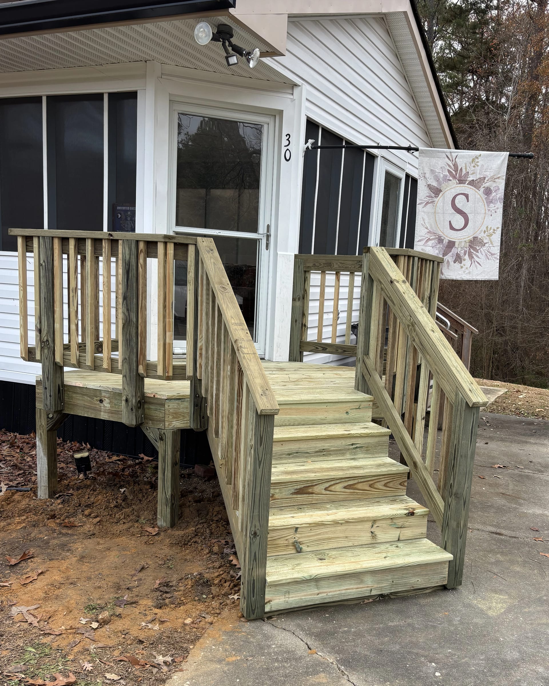 Small entry staircase built with pressure-treated wood and railing.