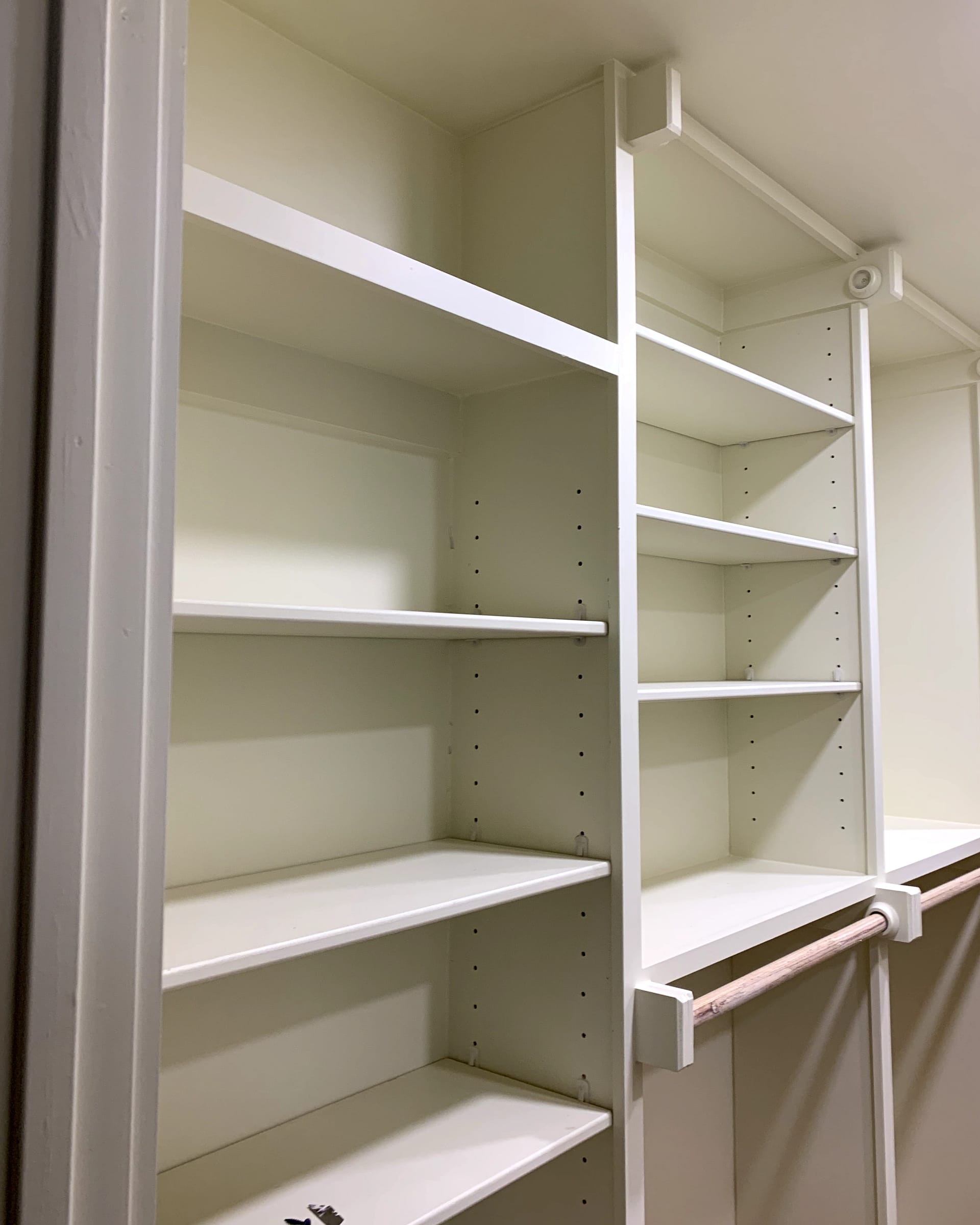 Custom built-in closet shelving with adjustable shelves and hanging rod supports.
