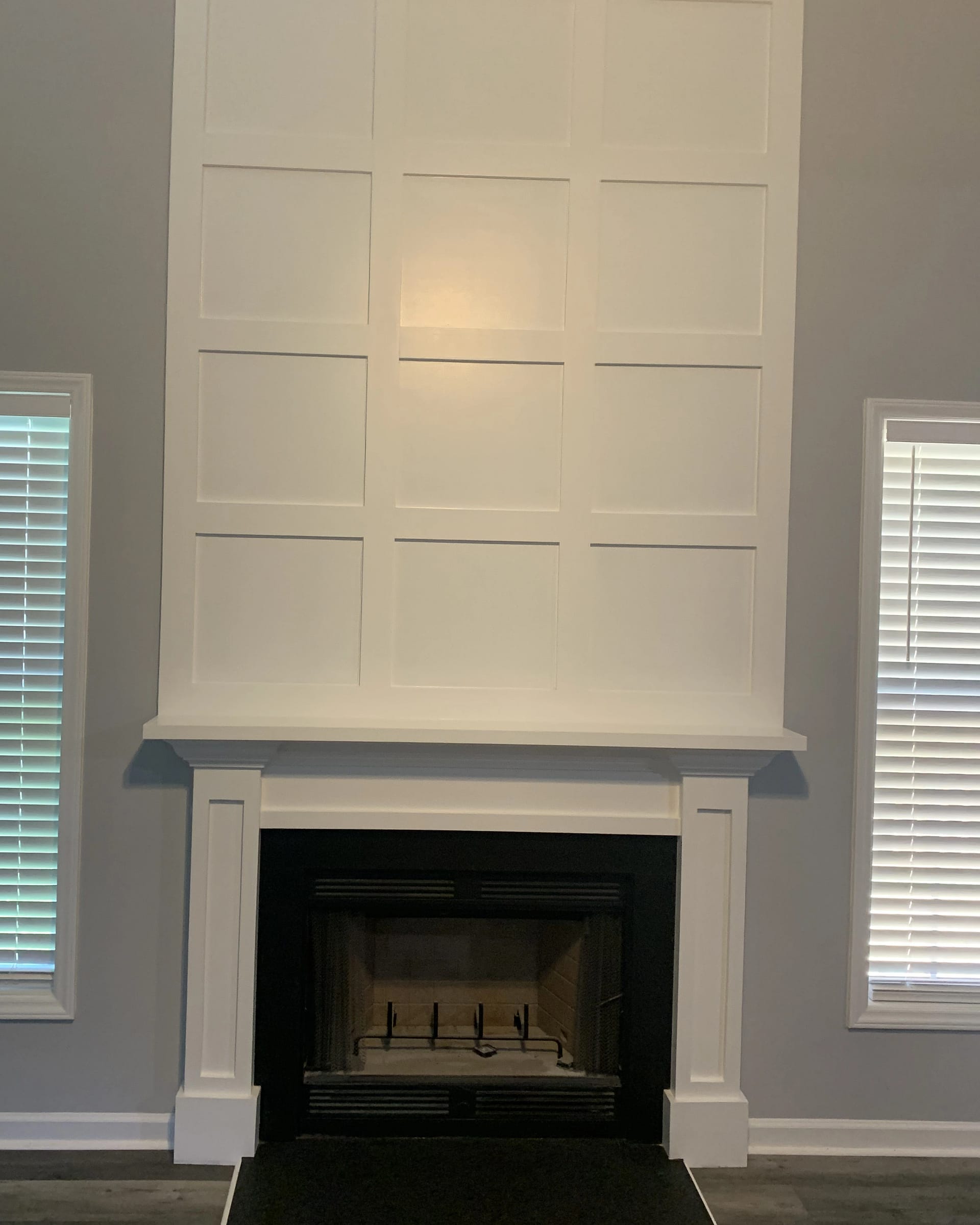 Fireplace with tall paneled feature wall and classic trim detailing.