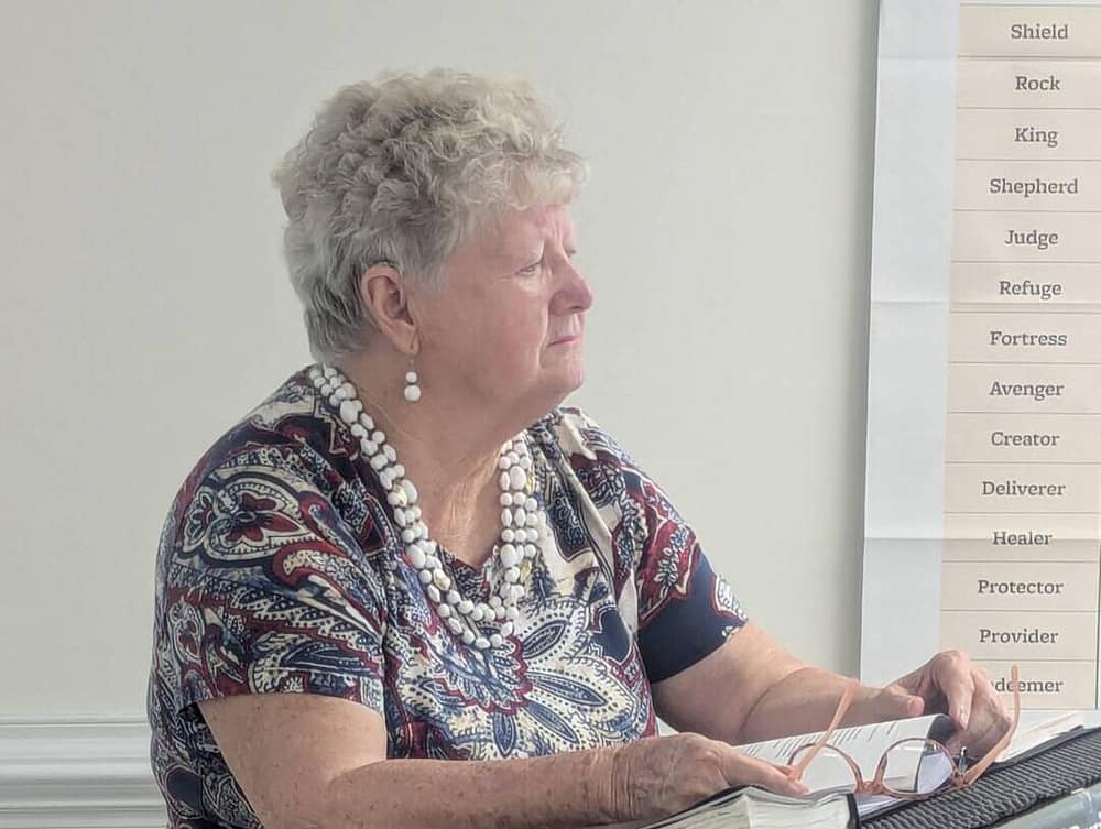 Woman looking out at her peers as she discusses topics at a Women's ministry meeting.